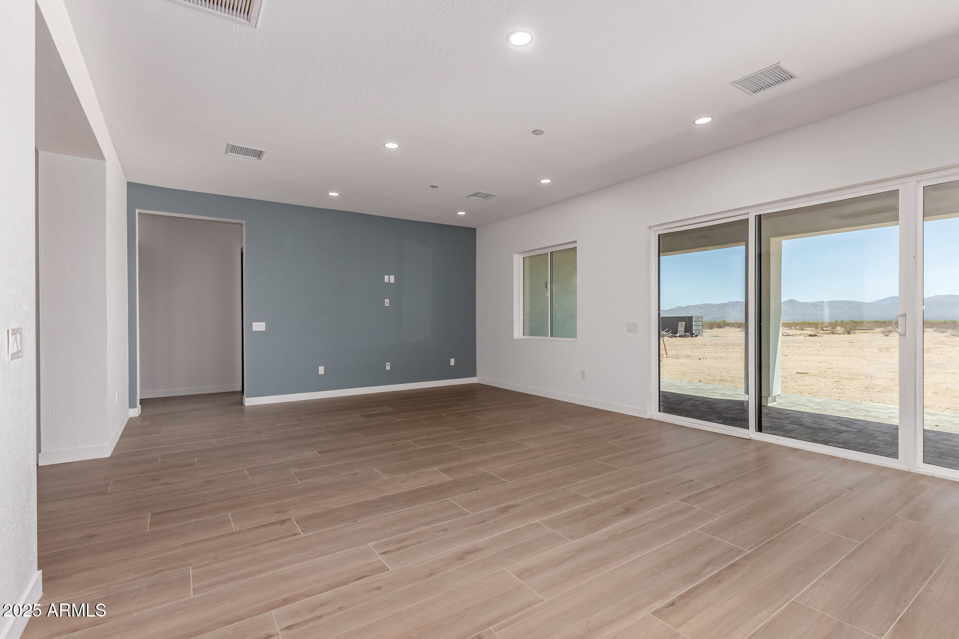 25117 West McArthur Road Wittmann, AZ 85361 - Photo 5 of 43 an empty room with wooden floor and windows