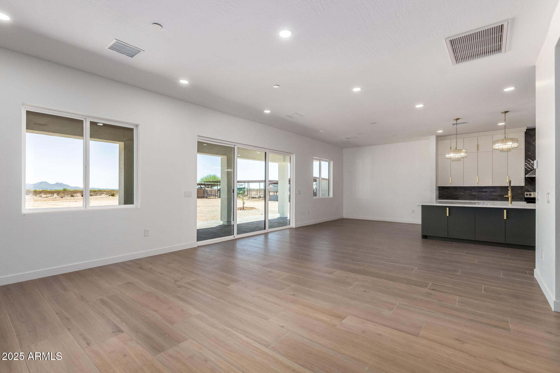 25117 West McArthur Road Wittmann, AZ 85361 - Photo 6 of 43 a view of an empty room with a window and wooden floor