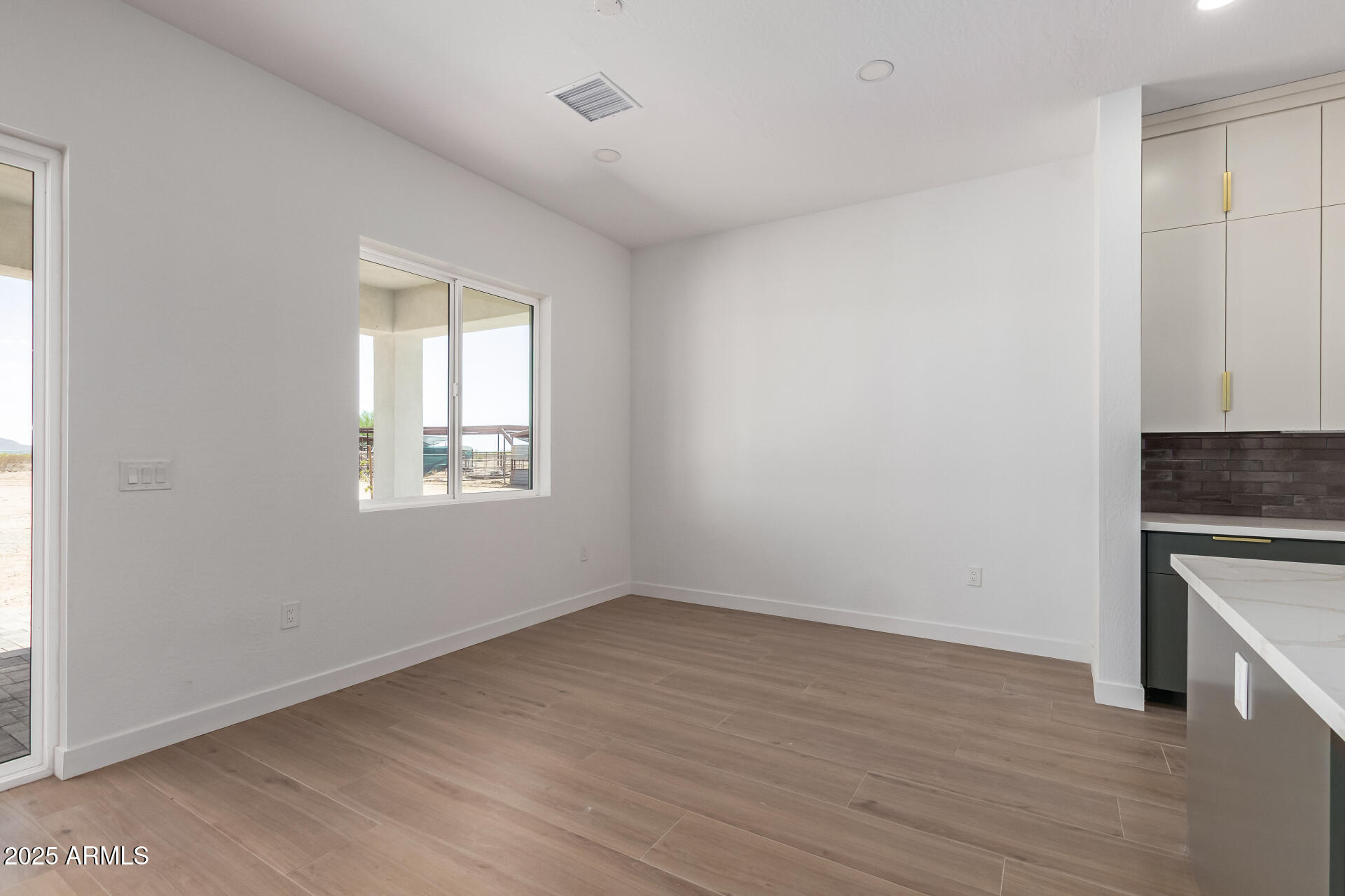 25117 West McArthur Road Wittmann, AZ 85361 - Photo 8 of 43 wooden floor in an empty room with a window
