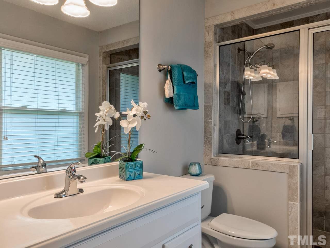 1016 Winona Road Raleigh, NC 27609 - Photo 15 of 25 a bathroom with a sink and mirror with toilet