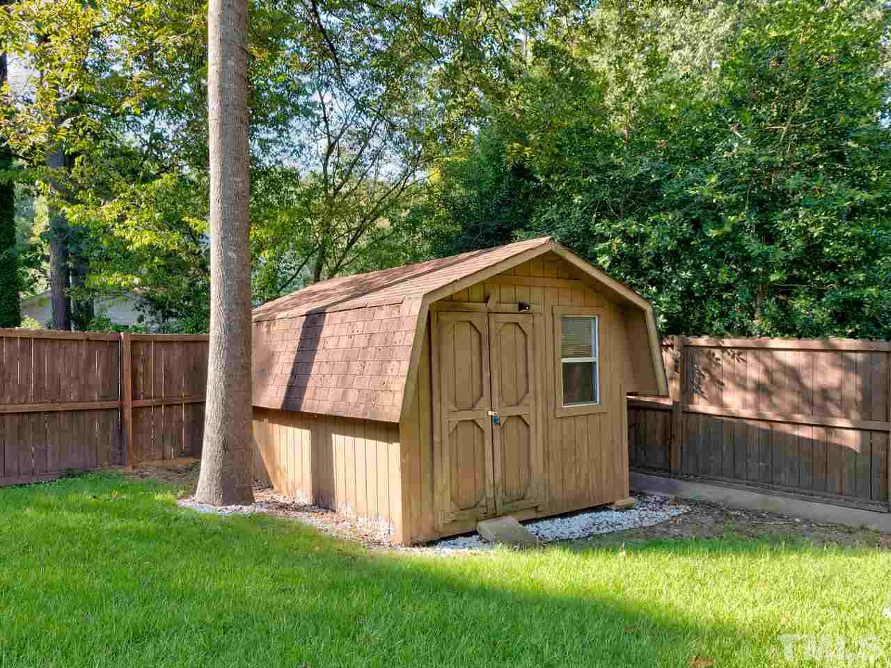 1016 Winona Road Raleigh, NC 27609 - Photo 22 of 25 a view of backyard with small cabin and wooden fence