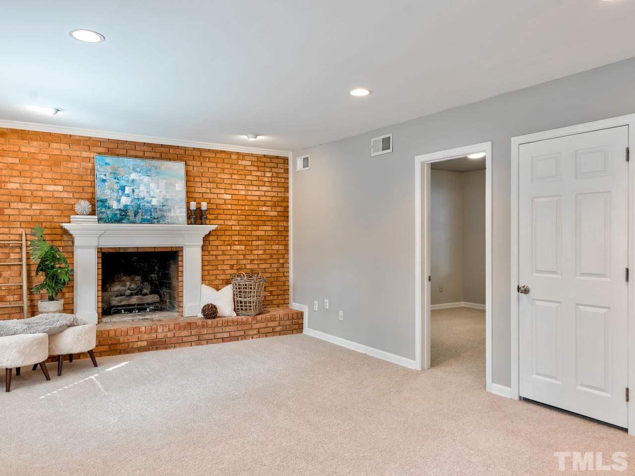 1016 Winona Road Raleigh, NC 27609 - Photo 8 of 25 an empty room with furniture and a fireplace