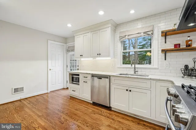 a kitchen with stainless steel appliances kitchen island granite countertop a refrigerator and a stove