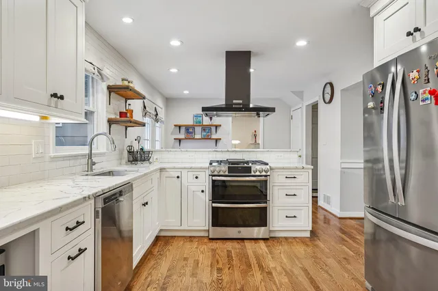 a kitchen with stainless steel appliances granite countertop a sink a stove a refrigerator and window