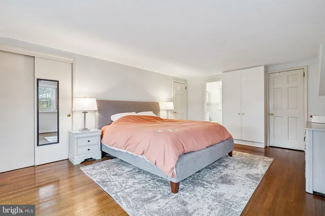 a spacious bedroom with a bed and wooden floor