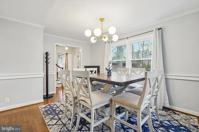 a dining room with wooden floor and a chandelier