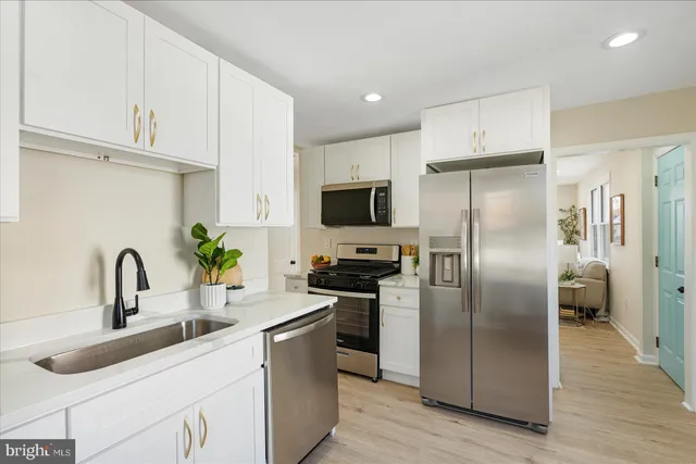 a kitchen with stainless steel appliances a refrigerator a sink a stove a microwave and a refrigerator