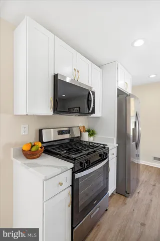 a kitchen with stainless steel appliances a stove a microwave a sink and cabinets
