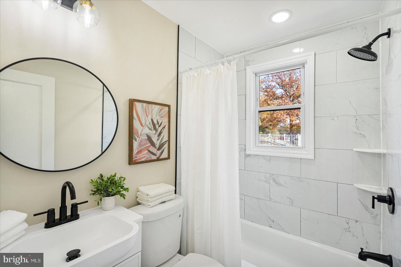 405 Margaret Avenue Baltimore, MD 21221 - Photo 16 of 38 a bathroom with a sink a mirror and a bathtub