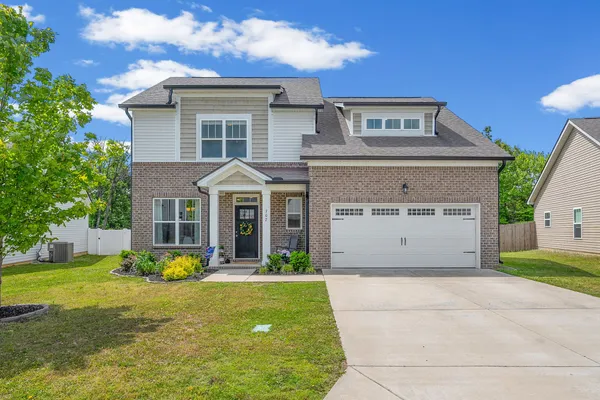 a front view of a house with a yard and garage