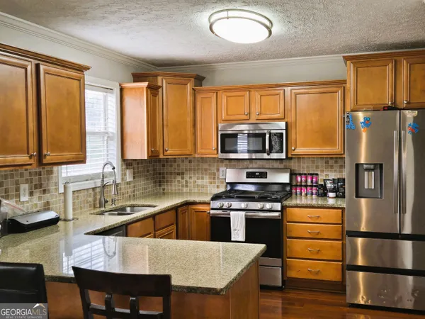 a kitchen with a refrigerator a stove a sink and dishwasher with wooden floor
