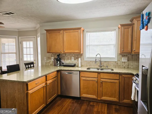 a kitchen with stainless steel appliances granite countertop wooden cabinets a sink and a stove