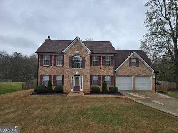 a front view of a house with a garden