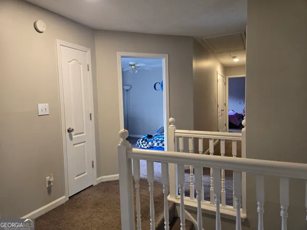 a view of a hallway with toilet and entryway