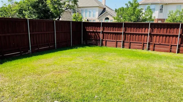 a view of a backyard with wooden fence and a small barn