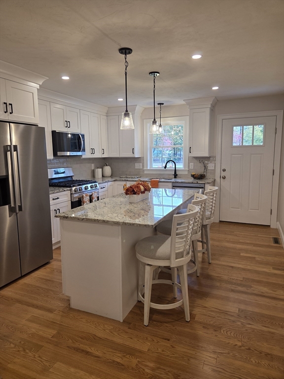 519 Mendon Road, Unit 519 Attleboro, MA 02703 - Photo 3 of 22 a kitchen with stainless steel appliances granite countertop a refrigerator a sink a stove a dining table and chairs