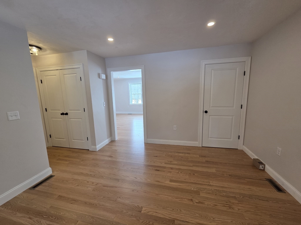 519 Mendon Road, Unit 519 Attleboro, MA 02703 - Photo 7 of 22 a view of an empty room with wooden floor and closet