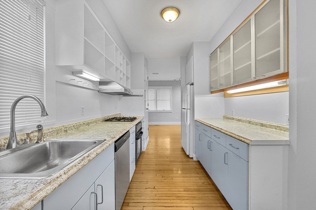 172 Maplewood Street Watertown, MA 02472 - Photo 19 of 42 a kitchen with granite countertop a sink and a stove