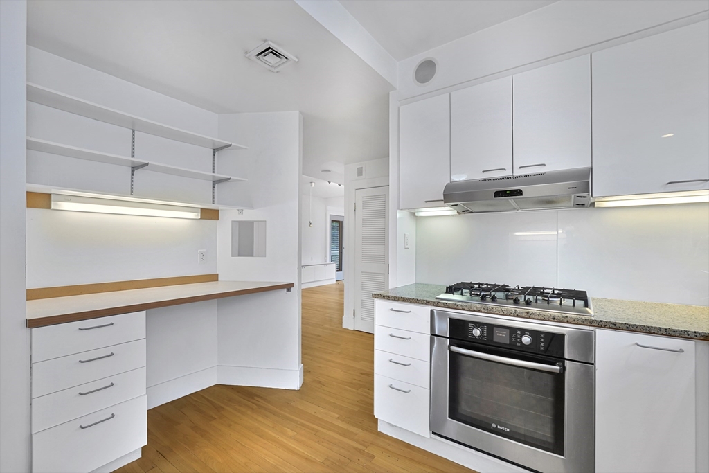 172 Maplewood Street Watertown, MA 02472 - Photo 3 of 42 a kitchen with stainless steel appliances white cabinets and a stove a oven with white countertops