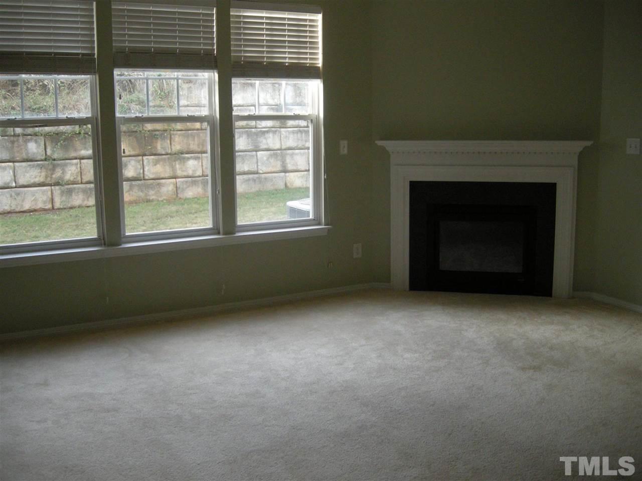 8423 Header Stone Drive Raleigh, NC 27613 - Photo 5 of 14 an empty room with a fireplace and windows