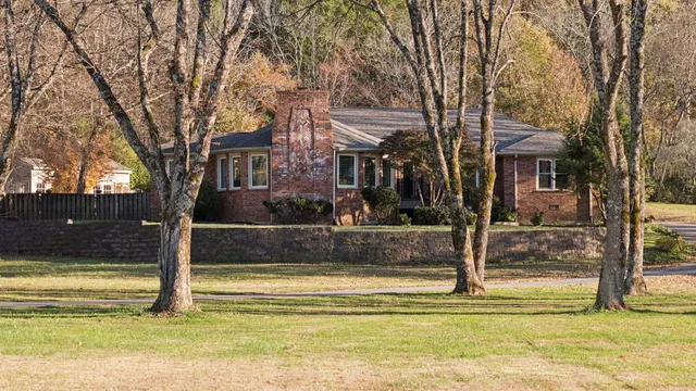 a view of fountain in front of house with trees