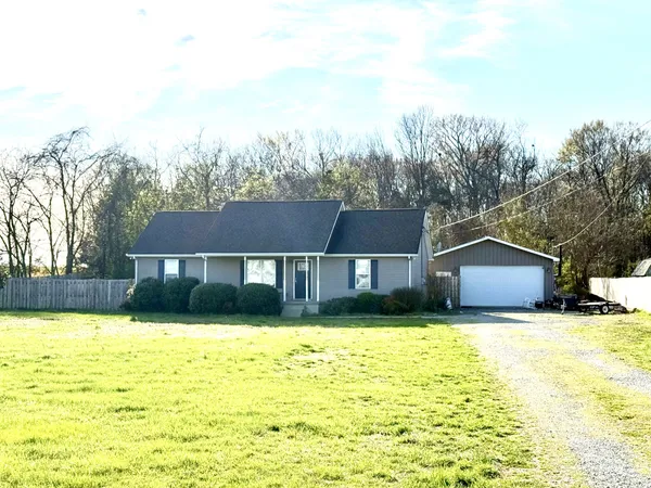 a view of a house with a big yard and large trees
