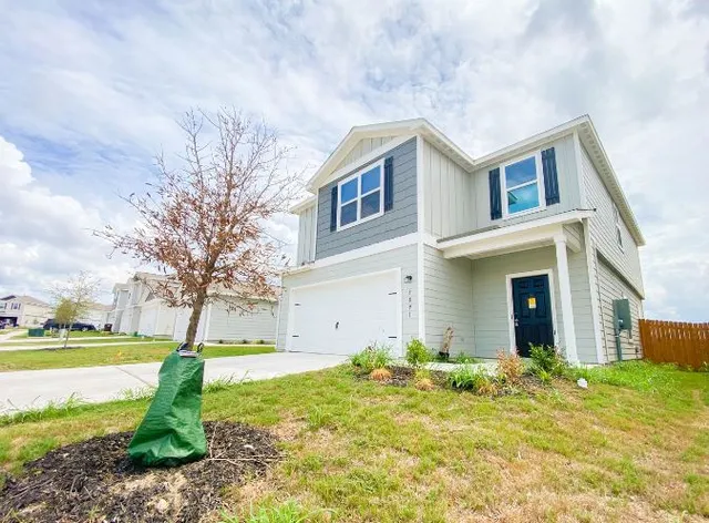 a view of a house with a yard and tree s