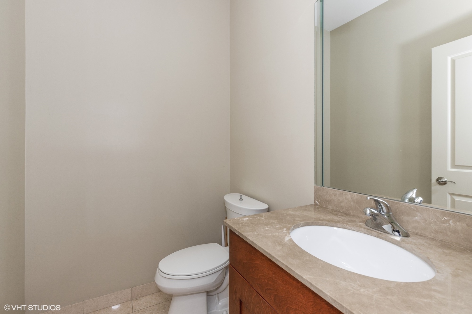21 Northfield Terrace, Unit 21 Wheeling, IL 60090 - Photo 9 of 18 a bathroom with a granite countertop toilet a sink and a mirror