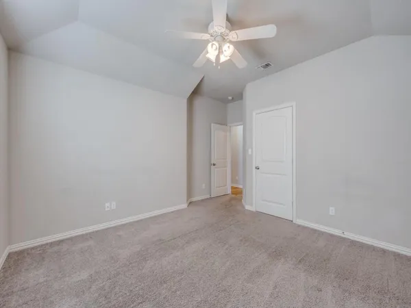 a view of an empty room with a chandelier fan
