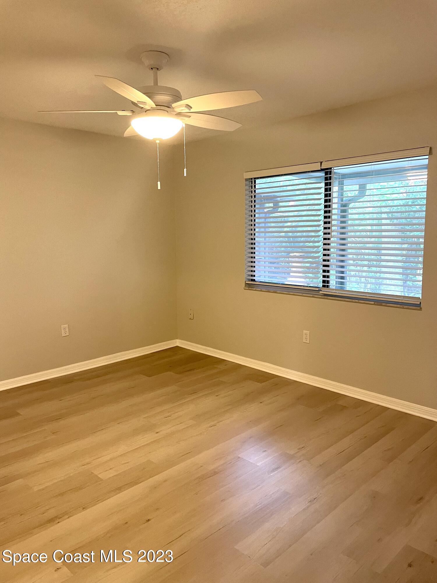 179 Shell Place, Unit 36 Rockledge, FL 32955 - Photo 13 of 20 a view of an empty room with wooden floor and a window