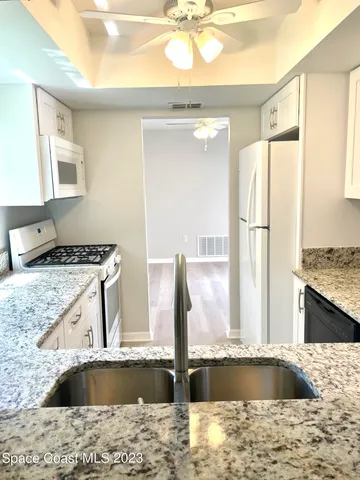 a kitchen with a sink granite counter tops and a wooden cabinets