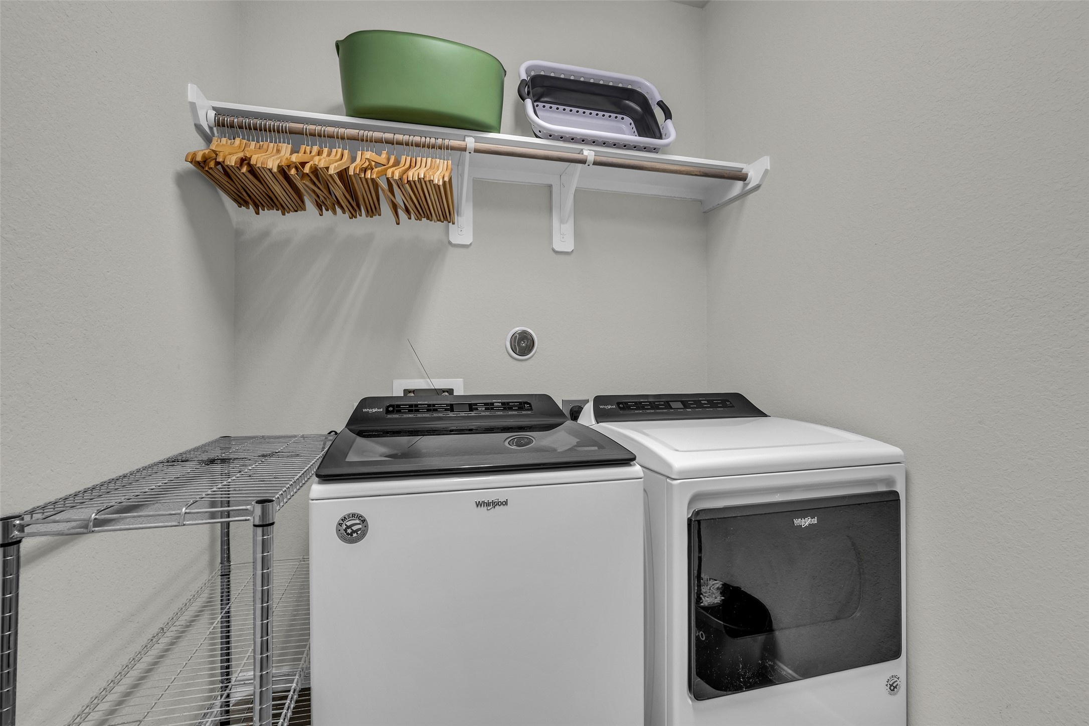 2344 Hagerman Road Conroe, TX 77384 - Photo 12 of 27 Efficient laundry room with modern washer and dryer, ample shelving, and a hanging rod for convenience.
