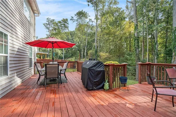 a view of a roof deck with table and chairs under an umbrella with wooden floor