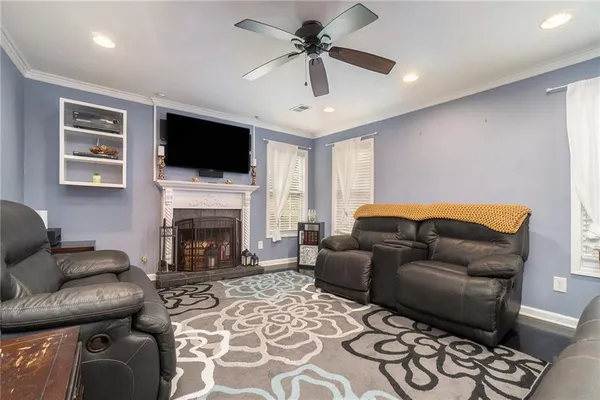 a living room with furniture a flat screen tv and a fireplace