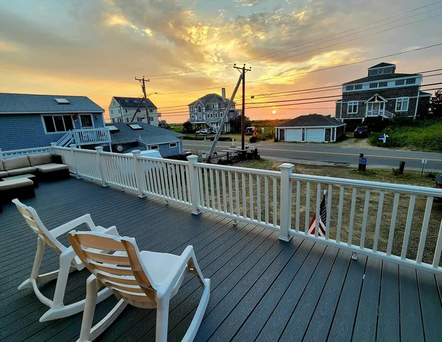 a view of a balcony with wooden chairs