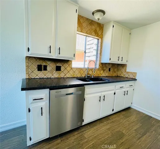 a kitchen with stainless steel appliances granite countertop a sink a stove and cabinets