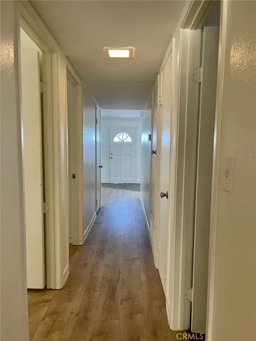 a view of a hallway with wooden floor
