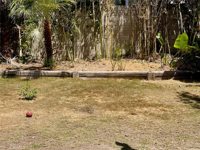 a view of swimming pool with a lawn chairs and palm tree