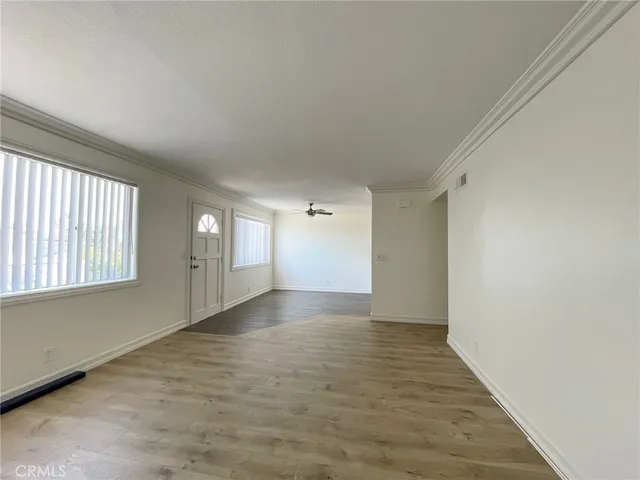 a view of a big room with wooden floor and windows