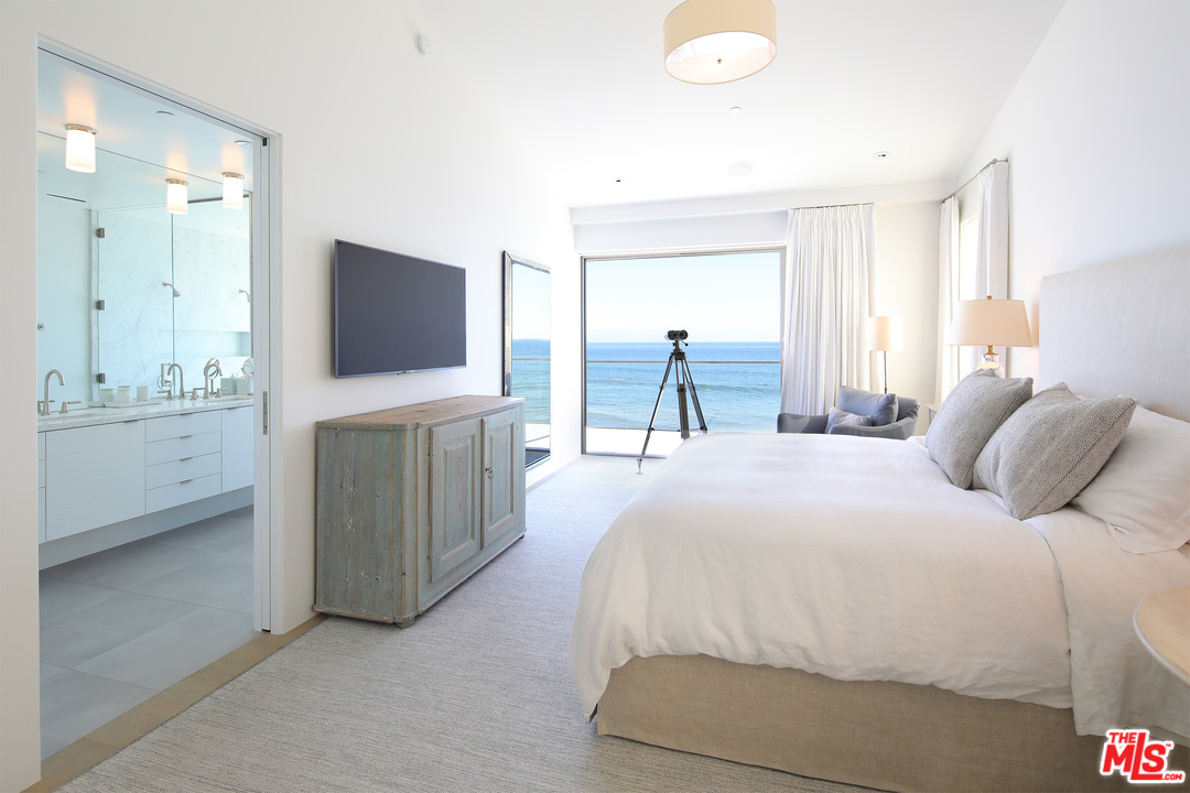 23956 Malibu Road Malibu, CA 90265 - Photo 13 of 26 a bedroom with a bed and a flat tv screen on wall