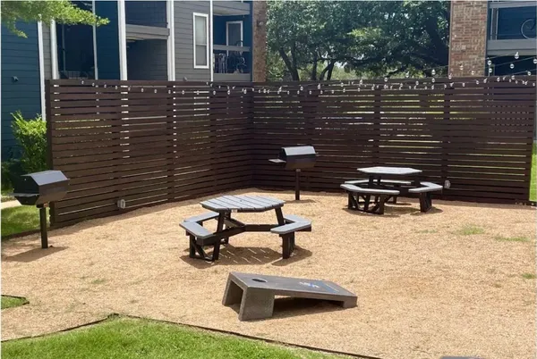 a view of a patio with table and chairs with wooden floor and fence