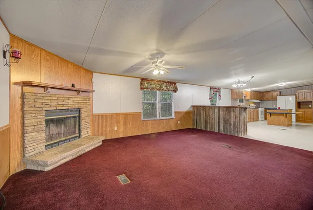 a view of an empty room with a fireplace and a window