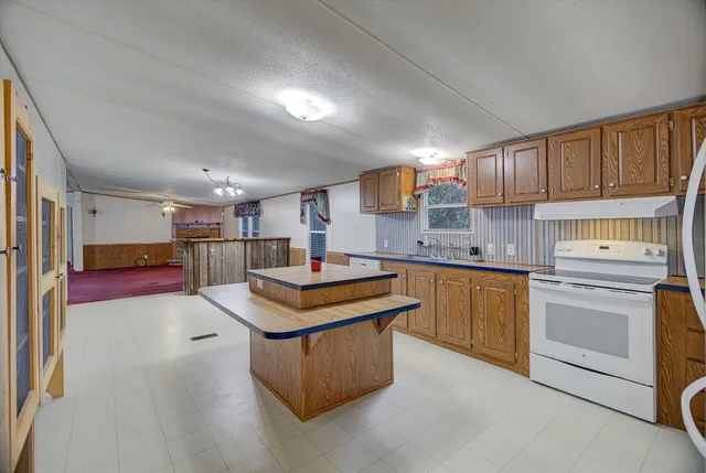 a kitchen with stainless steel appliances granite countertop a sink stove and cabinets