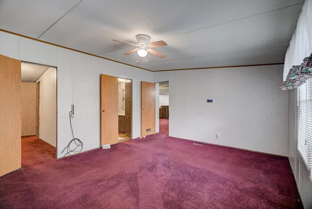 an empty room with fan and windows