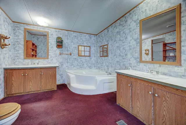 a spacious bathroom with a sink a toilet and mirror