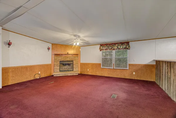 an empty room with a fireplace and window