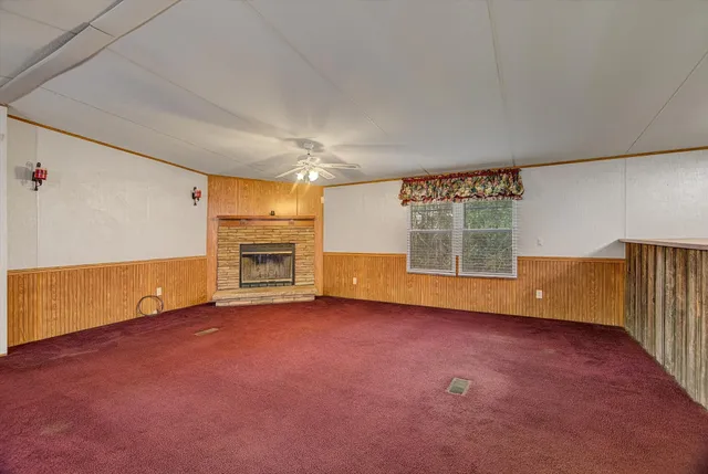 an empty room with a fireplace and window