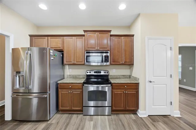 a kitchen with wooden cabinets and stainless steel appliances