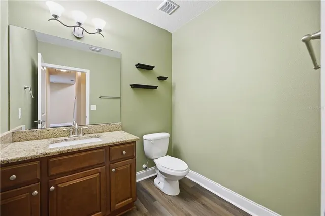a bathroom with a granite countertop toilet sink and mirror