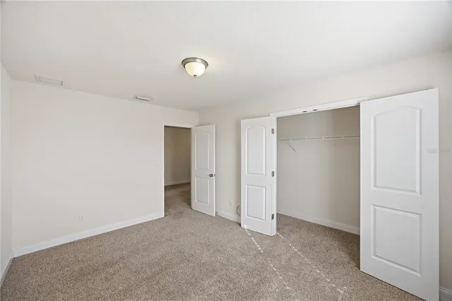 an empty room with a window and a ceiling fan